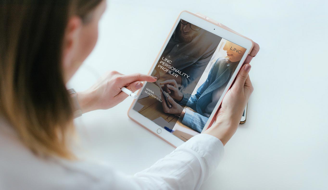 A woman operates a tablet with the LINC Personaliy Profiler screen open.